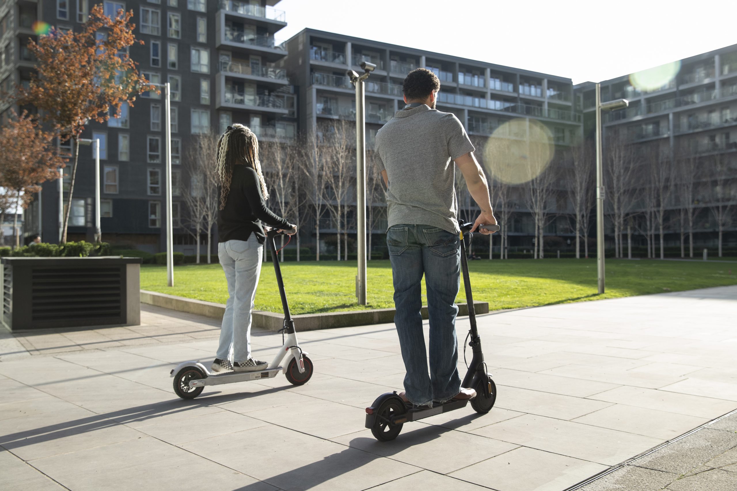 full-shot-people-traveling-with-electric-scooters
